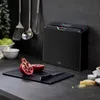 A kitchen counter scene with a set of cutting boards, a pomegranate, and kitchen utensils. Anteprima dell’immagine prodotto