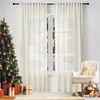 A festive Christmas scene with a decorated tree, gifts, and a chair next to a window with sheer curtains. Produktbild-Vorschau