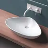 A white ceramic sink with a modern faucet mounted on a teal wall, placed on a wooden countertop. Produktbild-Vorschau