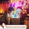 Two children are looking into a gift box with a glowing toy guitar inside, in a festive Christmas setting. Produktbild-Vorschau