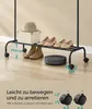 A clothing rack with shoes, a hat, and a box on it, with a robot vacuum cleaner on the floor below. Text overlays describe features and dimensions. Produktbild-Vorschau