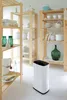 A white dehumidifier is placed on a white floor in front of wooden shelves filled with various household items. Anteprima dell’immagine prodotto