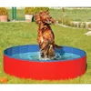 A dog is playing in a red and blue dog pool in a grassy yard. Anteprima dell’immagine prodotto