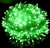 A tangled ball of green LED string lights against a black background.