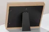 The back of a wooden photo frame with a black backing and a stand. Produktbild-Vorschau