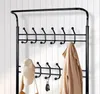 A black metal coat rack with multiple hooks, holding a beige jacket, a cap, and keys. Produktbild-Vorschau