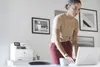 A woman is working on a laptop next to a printer in an office. Náhled obrázku produktu
