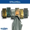 A stylish and modern coat rack with multiple wooden panels in different colors and black metal hooks, with a jacket hanging on one of the hooks. Produktbild-Vorschau