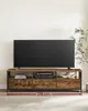 A wide, rustic-style TV stand with a large black television on top. Náhled obrázku produktu
