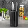 A black knife block with three silver knives is displayed on a countertop, with kitchen items like herbs, oil, and pasta in the background. Voir les images du produit