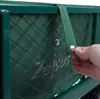 A close-up shot of a green wagon with a hand detaching a strap from a snap button. Produktbild-Vorschau