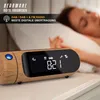 A digital radio alarm clock with a wood-grain finish is shown on a nightstand next to a sleeping person. Produktbild-Vorschau