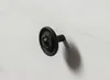 A close-up shot of a black drawer knob with an ornate design, attached to a white wooden surface. Produktbild-Vorschau