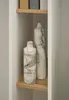 Two marble-patterned vases are displayed on a wooden shelf within a white shelving unit. Produktbild-Vorschau