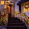 A decorated staircase and porch with Christmas lights and a wreath during a rain shower. Produktbild-Vorschau