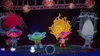 Four Trolls characters are dancing on a stage with speakers and lights. Produktbild-Vorschau