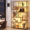 A gold-colored bookshelf with artificial marble shelves, displaying various items like wine bottles, glasses, and decorative objects, set against a white brick wall. Produktbild-Vorschau
