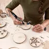 A person is using a Dremel rotary tool to engrave a wooden disc. Anteprima dell’immagine prodotto