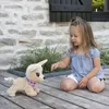 A young girl is playing with a stuffed dog on a wooden deck. Anteprima dell’immagine prodotto
