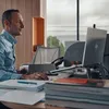 A man working on a laptop in an office. Produktbild-Vorschau