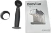 A coffee scoop, a metal ring, and an instruction manual for a Breville espresso machine are laid out on a white background. Produktbild-Vorschau