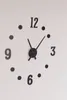 A close-up of a black wall clock with numbers and hands on a white background. Náhled obrázku produktu