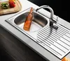 A stainless steel kitchen sink with a bottle inside and a faucet. Produktbild-Vorschau