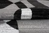 A close-up view of a folded rug with a geometric pattern. Voir les images du produit