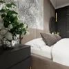 A close-up view of a bedroom with a bed, nightstand, and wall decor. Produktbild-Vorschau