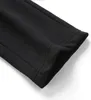 A close-up view of the hem of a black garment. Podgląd zdjęcia produktu