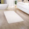 A bathroom scene with a bathtub, vanity, and a rug on the floor. Produktbild-Vorschau