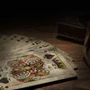 A close-up view of vintage playing cards fanned out on a wooden surface, with a small decorative box and twine in the background. Anteprima dell’immagine prodotto