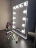 A makeup mirror with LED lights on a vanity table with makeup brushes and other cosmetics. Anteprima dell’immagine prodotto