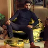 A man is sitting on a bean bag chair with a car print, with a small stool in front of him, also with a car print. The setting appears to be a modern living room or lounge area. Náhľad obrázku produktu