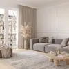 A modern living room with a gray sofa, a round wooden coffee table, and a large window overlooking a European city. Anteprima dell’immagine prodotto