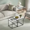 A living room scene with a couch, accent chair, and nesting coffee tables. Produktbild-Vorschau