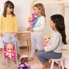 Three young girls are playing with baby dolls in a bedroom setting. Voir les images du produit