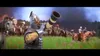 A medieval soldier blows a horn in a field with a battle in the background. Produktbild-Vorschau