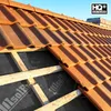 A close-up view of a roof under construction, showing terracotta tiles and the underlying insulation membrane. Produktbild-Vorschau