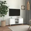 A white TV stand with a television on the wall above it, in a room with a plant and a rug. Produktbild-Vorschau