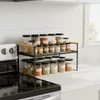 A kitchen counter with a spice rack filled with jars of spices next to a stove. Anteprima dell’immagine prodotto