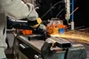 A person using an angle grinder to cut metal in a workshop. Náhled obrázku produktu