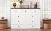 A white dresser with a dark brown top, placed in a room with sheer curtains and wooden side tables. Produktbild-Vorschau