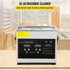 The image shows an ultrasonic cleaner on a counter in what appears to be a retail store setting, with shelves of products in the background. Voir les images du produit