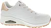 A side view of a white Skechers Uno sneaker with rose gold accents and a tan sole. Náhled obrázku produktu