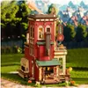 A detailed wooden model of a multi-story building, resembling a factory or shop, set in an outdoor environment with greenery and blurred background buildings. Podgląd zdjęcia produktu