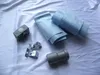 Various plumbing and shower drain components are laid out on a white fabric surface. Produktbild-Vorschau