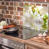 A kitchen scene with a glass stove top cover featuring a floral design, along with cooking ingredients and utensils. Náhľad obrázku produktu