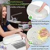 A woman is shown at a nail desk with a white wrist rest and nail polish bottles. Produktbild-Vorschau
