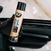 A gloved hand holds a can of K2 SIL silicone spray next to a car door. Produktbild-Vorschau